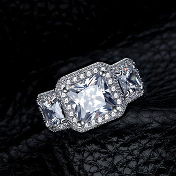 https://jolics.com/products/princess-cut-halo-three-stone-created-white-sapphire-engagement-ring?_pos=3&_psq=Halo+Engagement+Rings&_ss=e&_v=1.0